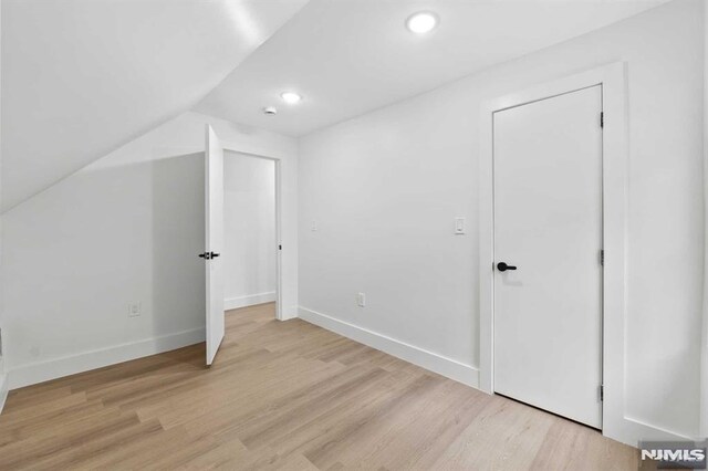 bonus room featuring light wood-type flooring and lofted ceiling