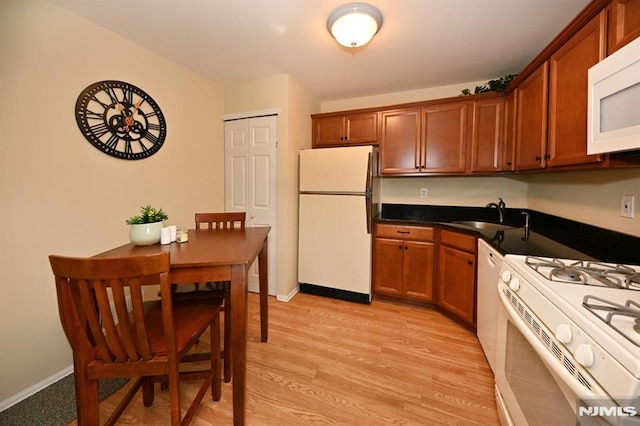 kitchen with white appliances, light hardwood / wood-style floors, and sink