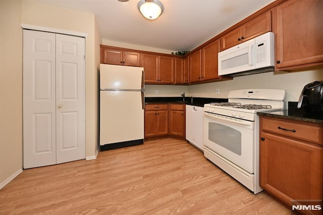 kitchen with white appliances, light hardwood / wood-style flooring, and sink