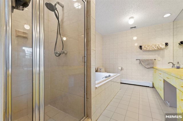 bathroom featuring tile walls, tile patterned floors, a baseboard heating unit, vanity, and plus walk in shower