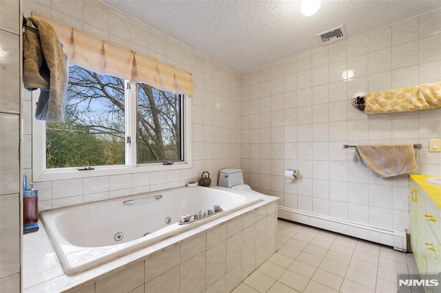 bathroom with tiled bath, a textured ceiling, tile walls, baseboard heating, and tile patterned floors