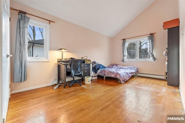 bedroom featuring light hardwood / wood-style floors, vaulted ceiling, and a baseboard radiator