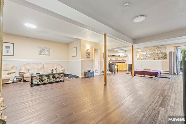 workout room with baseboard heating and hardwood / wood-style flooring