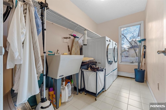 washroom featuring sink, a textured ceiling, baseboard heating, and independent washer and dryer