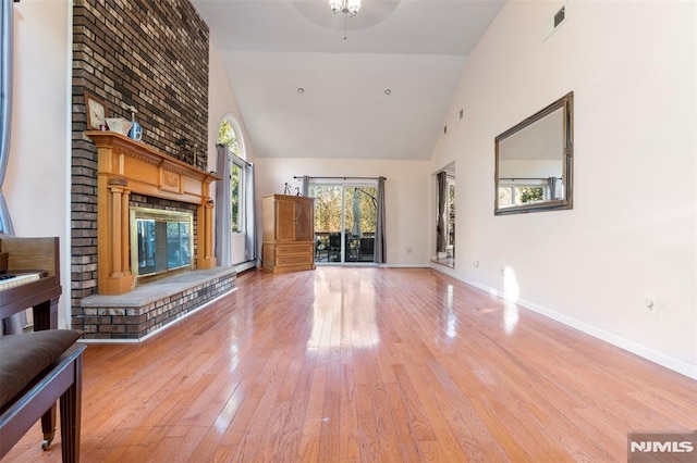 unfurnished living room featuring ceiling fan, high vaulted ceiling, a fireplace, and wood-type flooring