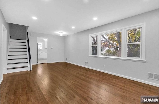 unfurnished living room with dark wood-type flooring