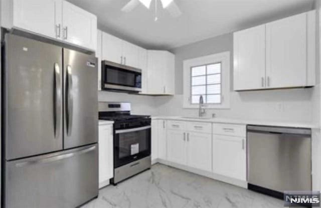 kitchen featuring white cabinets, ceiling fan, sink, and appliances with stainless steel finishes