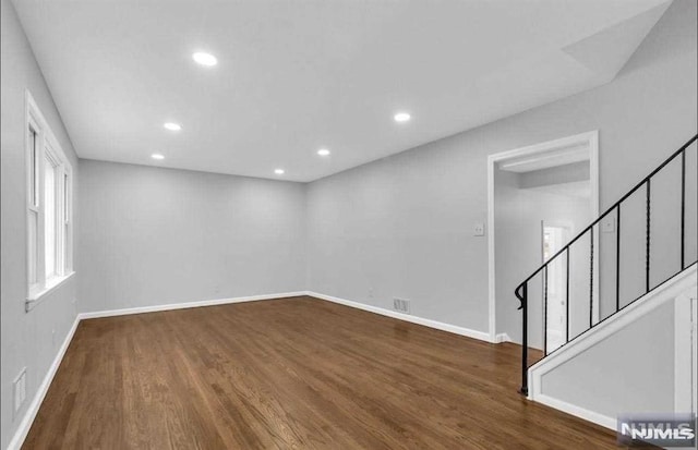 unfurnished room with dark wood-type flooring