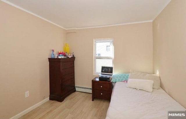 bedroom with light hardwood / wood-style floors, baseboard heating, and ornamental molding