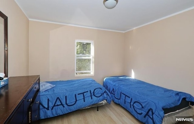 bedroom with hardwood / wood-style floors and crown molding