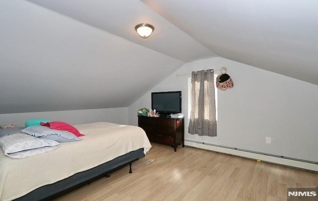 bedroom featuring vaulted ceiling, light hardwood / wood-style flooring, and a baseboard heating unit