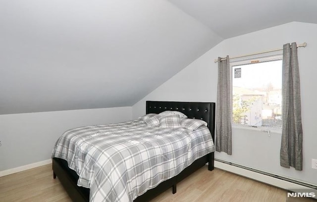 bedroom with lofted ceiling, light hardwood / wood-style flooring, and a baseboard radiator