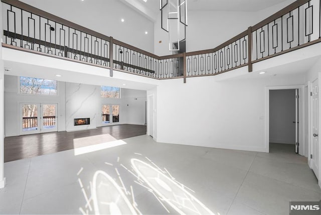 living room featuring tile patterned floors, a premium fireplace, and a high ceiling