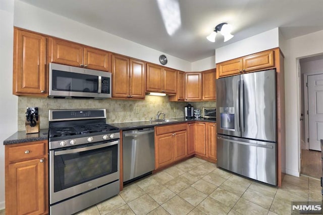 kitchen featuring sink, stainless steel appliances, tasteful backsplash, and light tile patterned floors