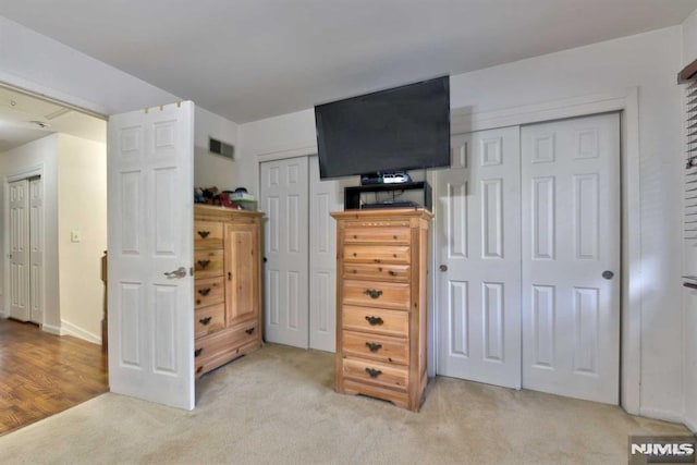 carpeted bedroom with two closets