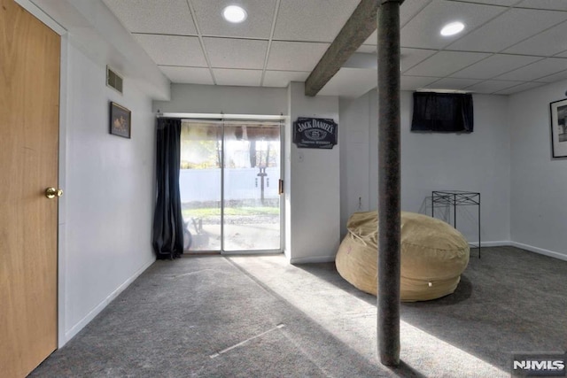 living area with carpet floors and a drop ceiling