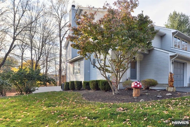 view of property exterior with a lawn and a garage