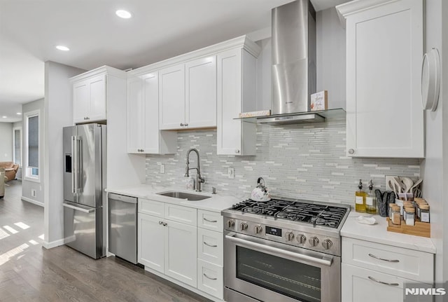 kitchen featuring white cabinets, sink, wall chimney exhaust hood, tasteful backsplash, and stainless steel appliances