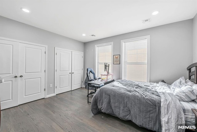 bedroom with hardwood / wood-style floors and multiple closets