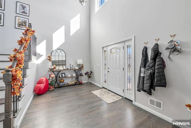 foyer entrance featuring dark hardwood / wood-style flooring and a towering ceiling