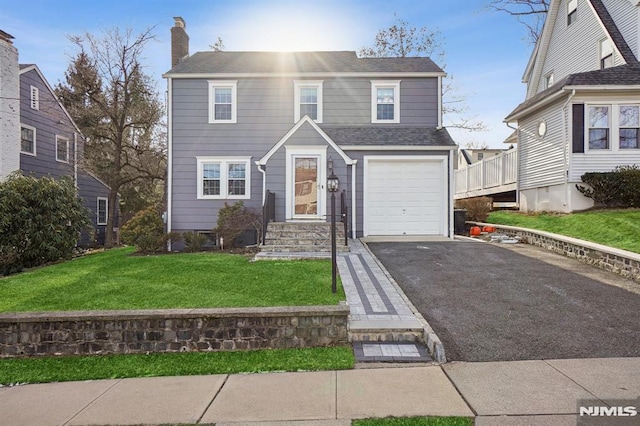 view of front facade with a garage and a front lawn