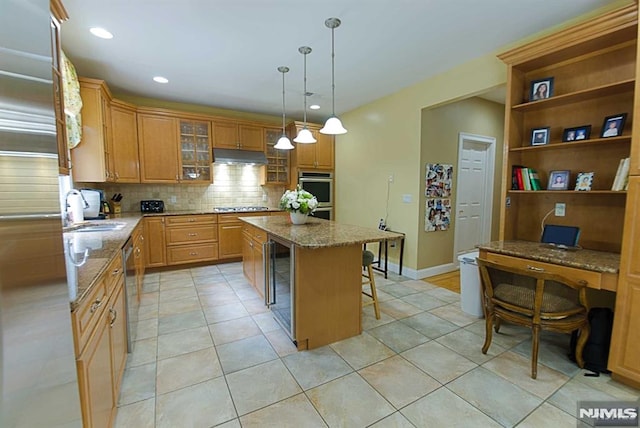 kitchen featuring a center island, beverage cooler, a breakfast bar area, appliances with stainless steel finishes, and sink