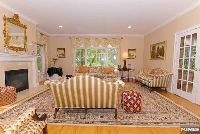 living room featuring crown molding, a fireplace, and hardwood / wood-style flooring