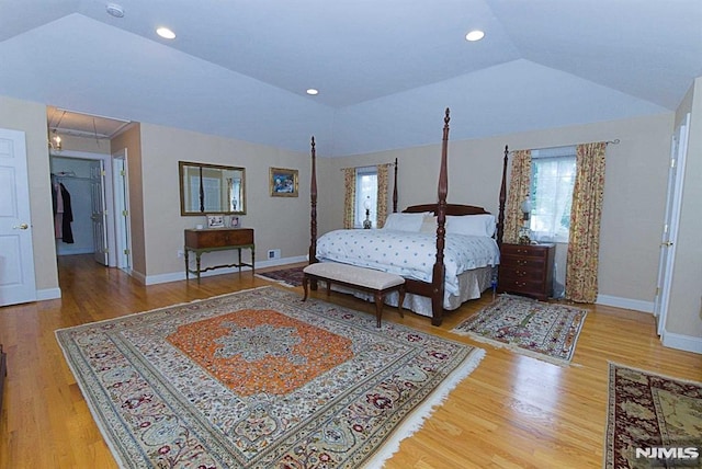 bedroom with vaulted ceiling and hardwood / wood-style flooring