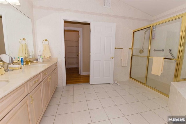 bathroom featuring walk in shower, tile patterned flooring, vaulted ceiling, and vanity