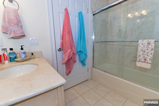 bathroom featuring bath / shower combo with glass door, tile patterned floors, and vanity