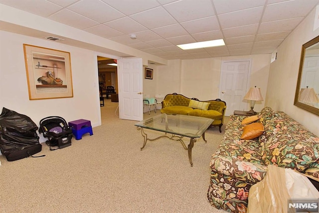 carpeted living room with a drop ceiling