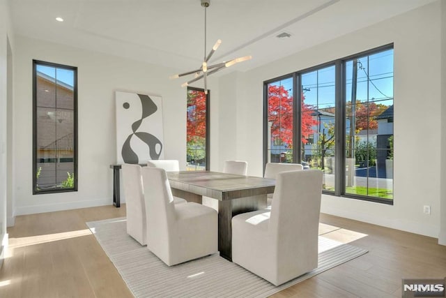 dining room with hardwood / wood-style floors and an inviting chandelier