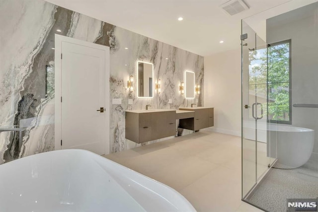 bathroom featuring plenty of natural light, shower with separate bathtub, vanity, and tile walls