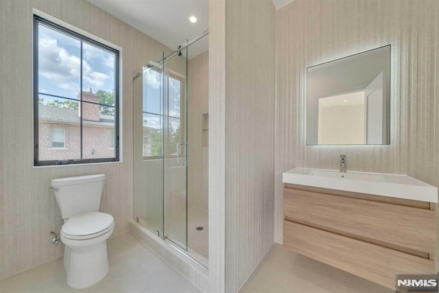 bathroom with vanity, toilet, and a shower with shower door