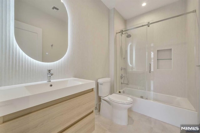 full bathroom featuring tile patterned flooring, combined bath / shower with glass door, toilet, and vanity