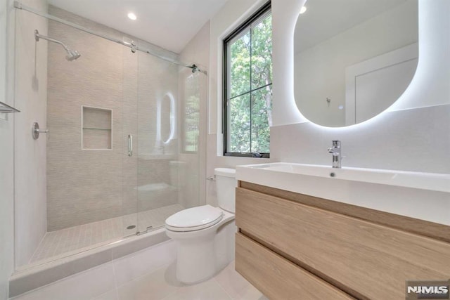 bathroom with tile patterned floors, a shower with door, vanity, and toilet