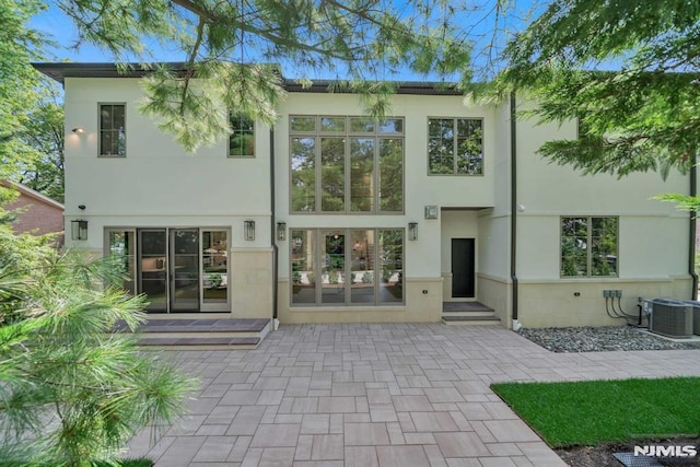 rear view of property with french doors, a patio, and central AC unit