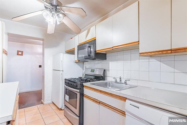 kitchen featuring white cabinets, stainless steel gas stove, dishwashing machine, and sink