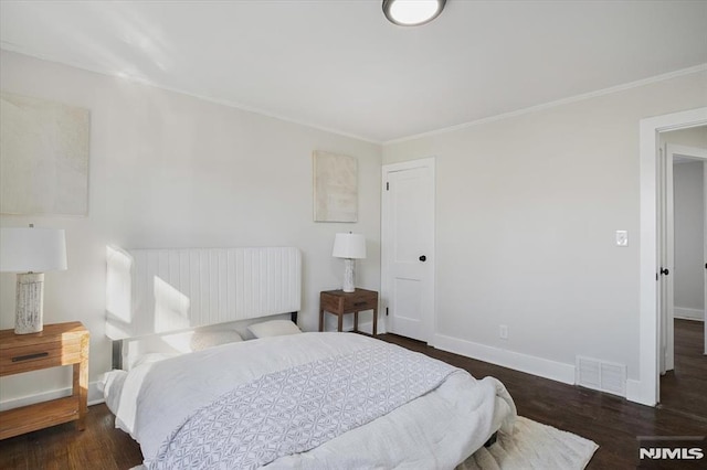 bedroom featuring crown molding and dark hardwood / wood-style floors