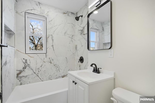 full bathroom with toilet, vanity, and tiled shower / bath