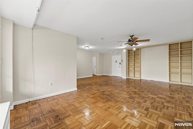 empty room with ceiling fan and light parquet flooring