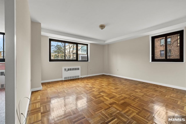 empty room with parquet floors and radiator heating unit