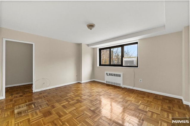 spare room with parquet floors and radiator heating unit