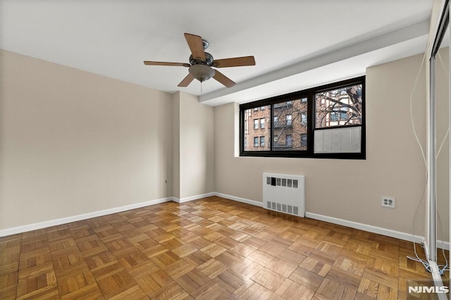 unfurnished room with ceiling fan, parquet flooring, and radiator