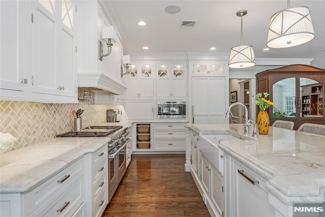 kitchen featuring a kitchen breakfast bar, white cabinetry, hanging light fixtures, and sink