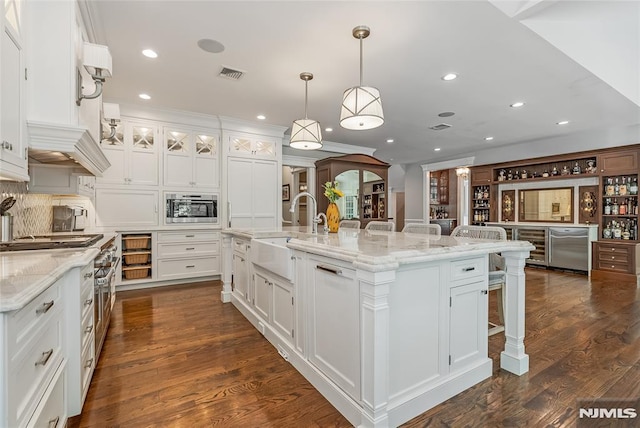 kitchen featuring a large island with sink, white cabinetry, and sink