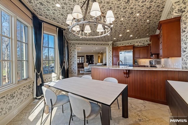 dining room featuring ornamental molding, a chandelier, and sink