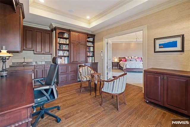 office featuring dark wood-type flooring, ornamental molding, and a raised ceiling