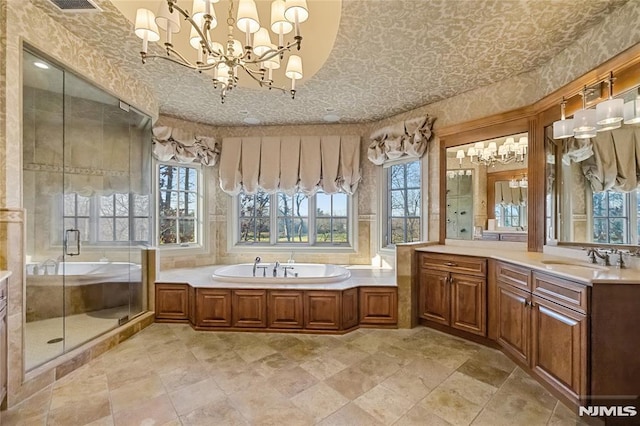 bathroom featuring an inviting chandelier, separate shower and tub, and vanity