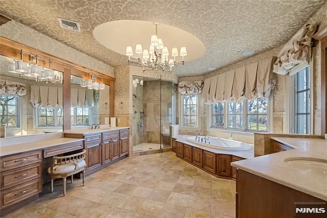 bathroom with vanity, independent shower and bath, and a notable chandelier